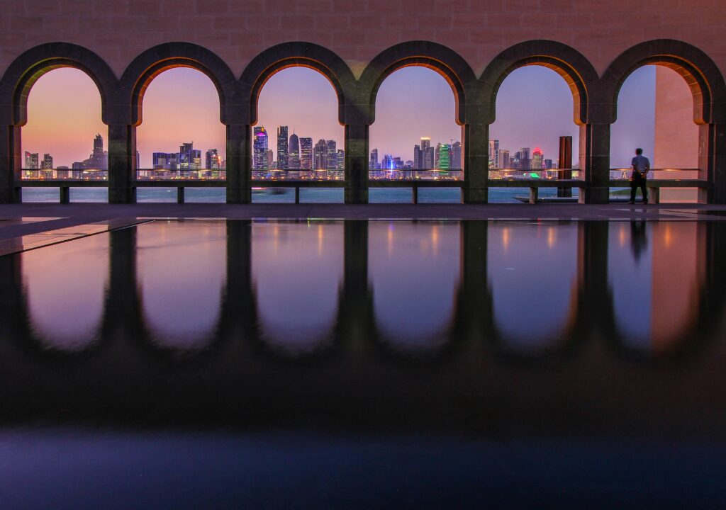 Doha skyline at dusk framed by arches, Qatar